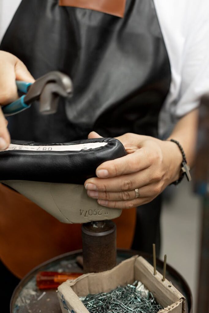 Shoemaker skillfully crafting shoes with hand tools, showcasing traditional craftsmanship.